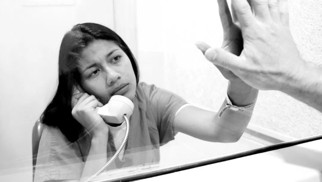 An inmate speaking with a visitor.