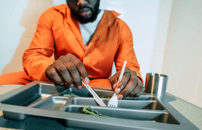 The black inmate eats one of the prison food recipes.