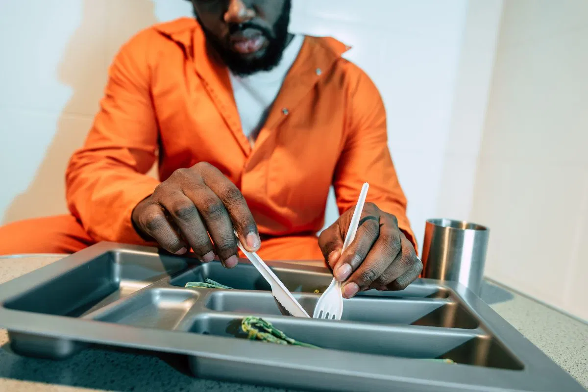 The black inmate eats one of the prison food recipes.