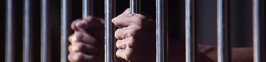 Inmate holding the bar inside the prison