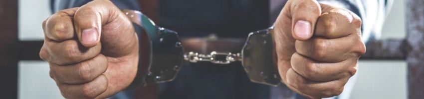 handcuffed man inside his prison cell