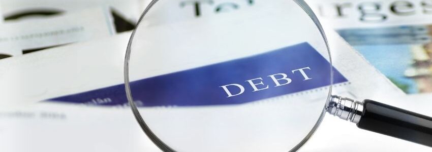 A magnifying glass focusing on the word debt.