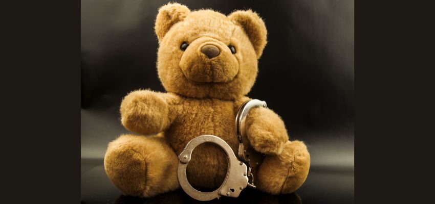 A teddy bear with handcuffs.