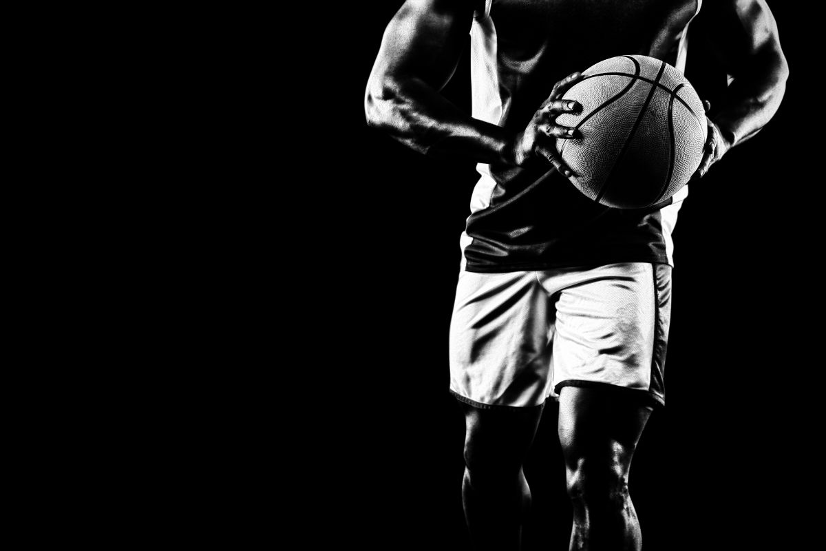 A black and white photo of a man holding a basketball ball